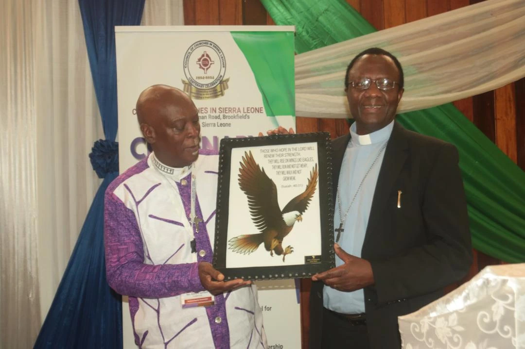 Rt. Rev. Henry Samuels, President of CCSL receiving the gift from AACC General Secretary Rev. Dr. Fidon Mwombeki 